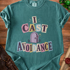 Green t-shirt with "I CAST AVOIDANCE" text and a purple door graphic.