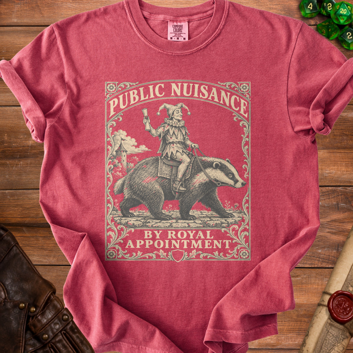 Red t-shirt graphic with a jester riding a badger, text: Public Nuisance by Royal Appointment.