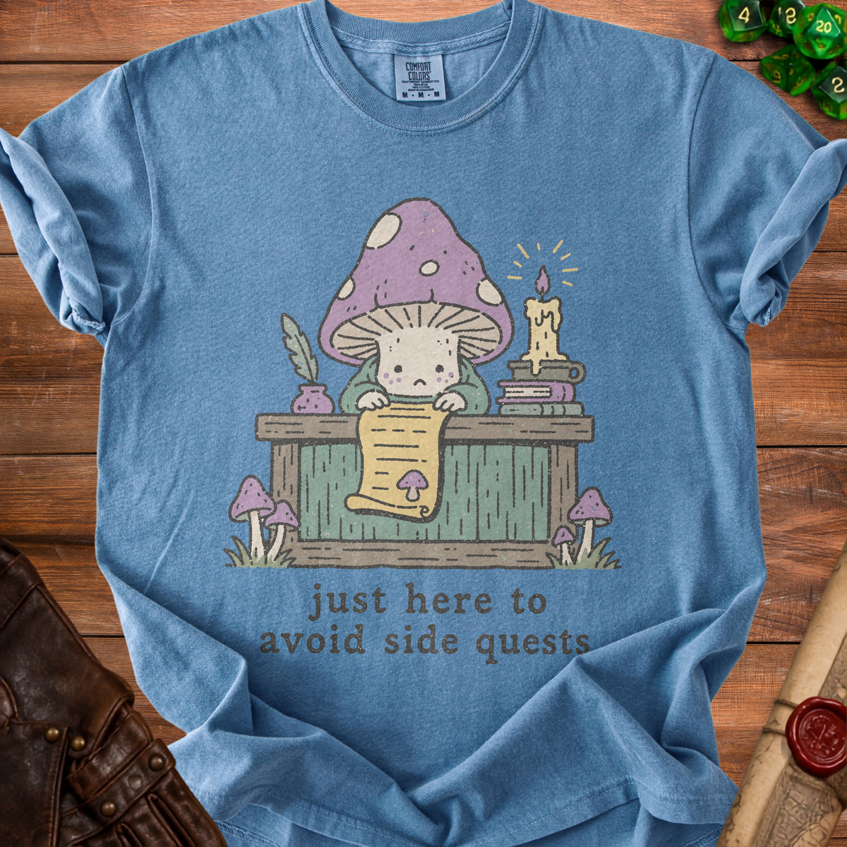 Blue t-shirt with cartoon mushroom at desk, reading scroll, saying "just here to avoid side quests."