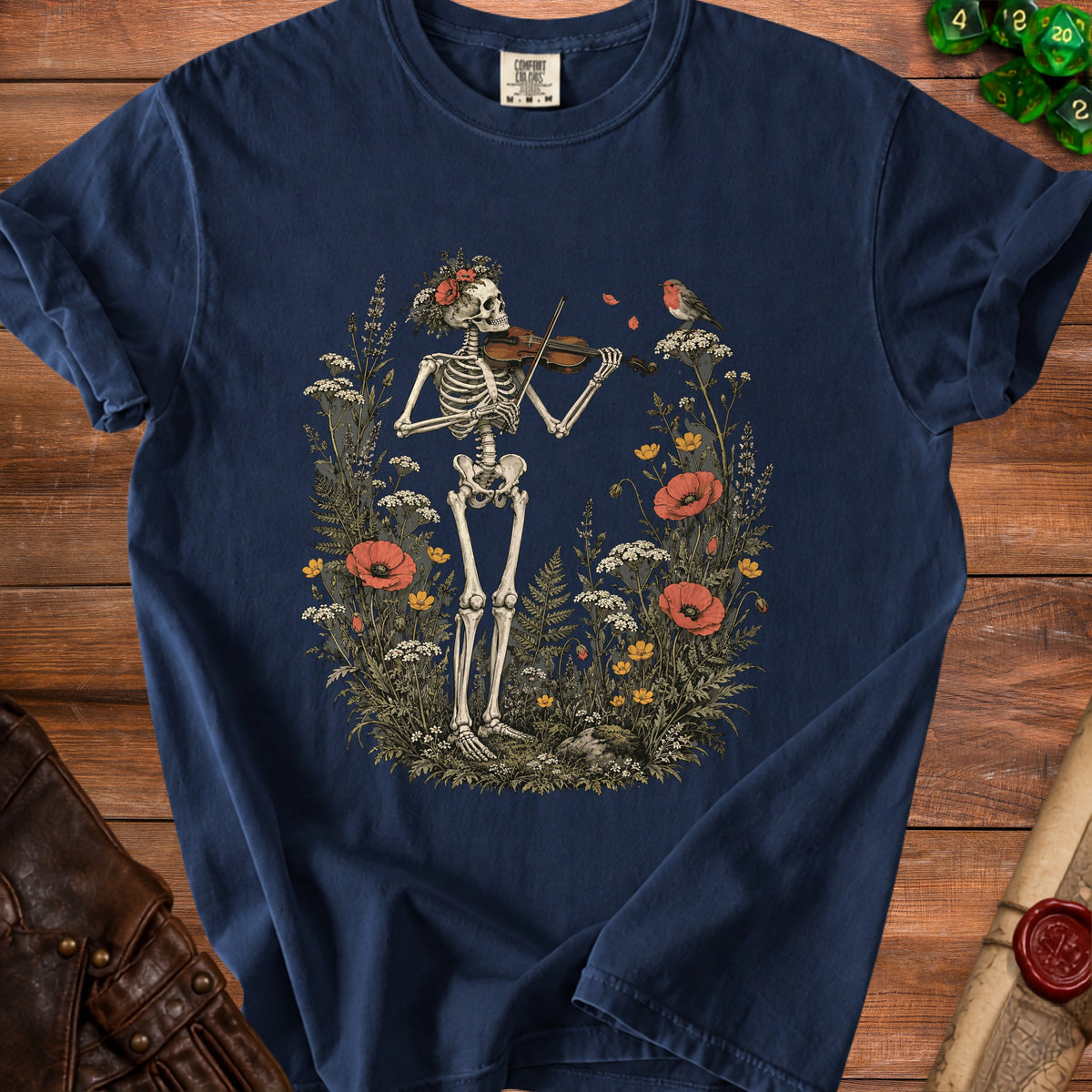 A dark blue t-shirt featuring a skeleton playing a violin surrounded by wildflowers and a bird.