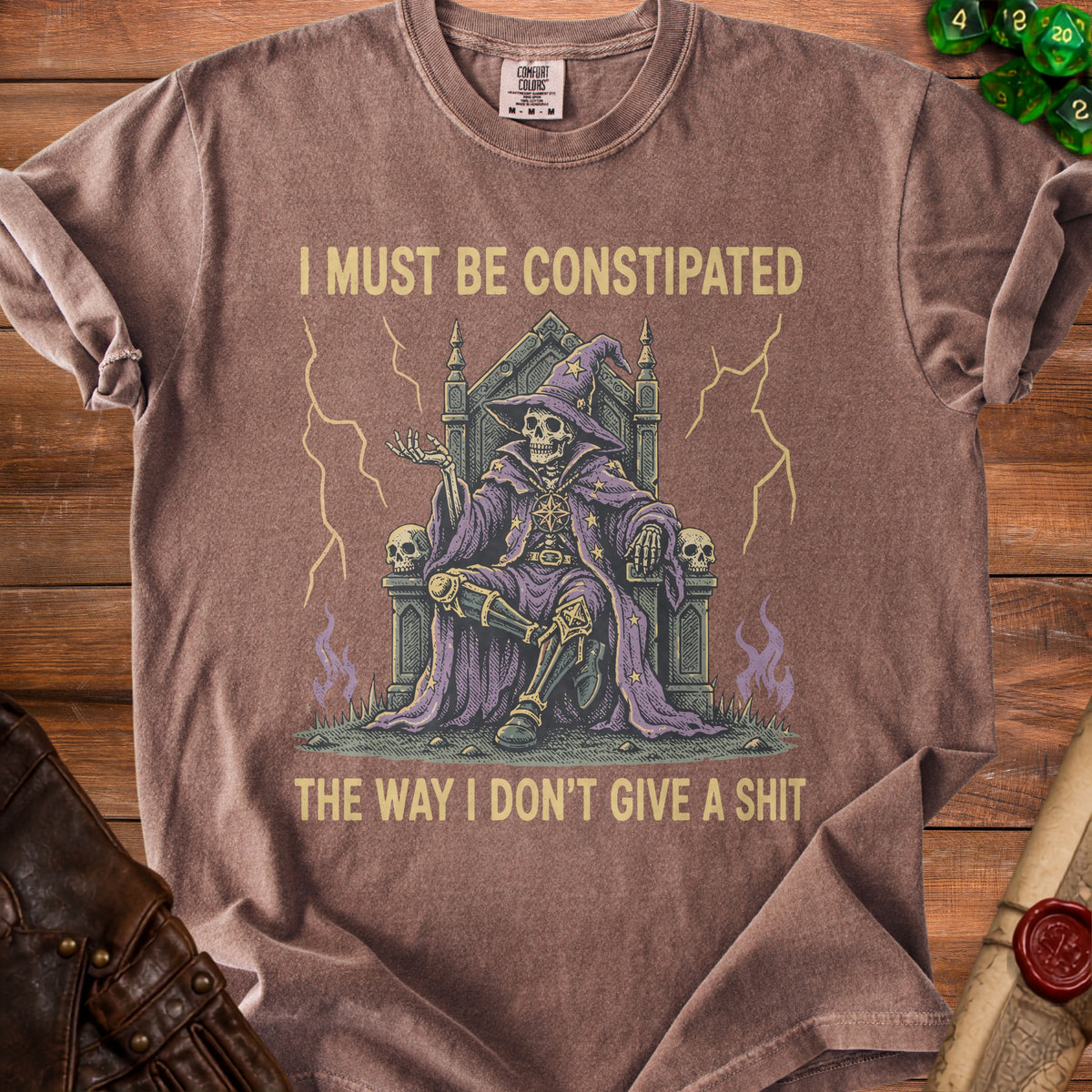 T-shirt with a skeleton wizard graphic and the text "I MUST BE CONSTIPATED THE WAY I DON'T GIVE A SHIT".