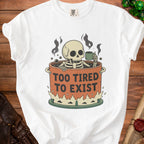 Skeleton in a pot with coffee mug, text reads "Too Tired To Exist".