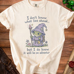 Cream t-shirt with wizard frog graphic and text: "I don't know what lies ahead... but I do know it will be an adventur"