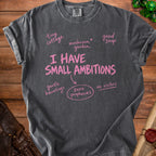 Dark grey t-shirt with pink text "I HAVE SMALL AMBITIONS" and related phrases.