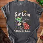 Shirt graphic of a goblin king offering a cut of meat, with text "Sir Loin" and "A Noble Cut Indeed".