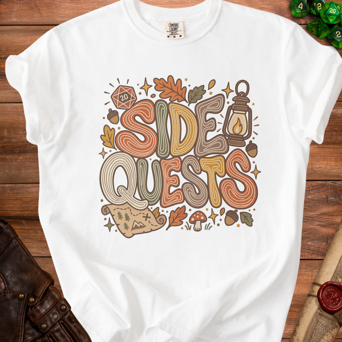 White t-shirt with "SIDE QUESTS" in colorful, retro font and fantasy elements.