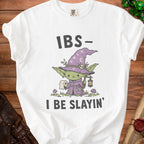 White t-shirt with a cartoon character holding toilet paper and text "IBS- I BE SLAYIN'".