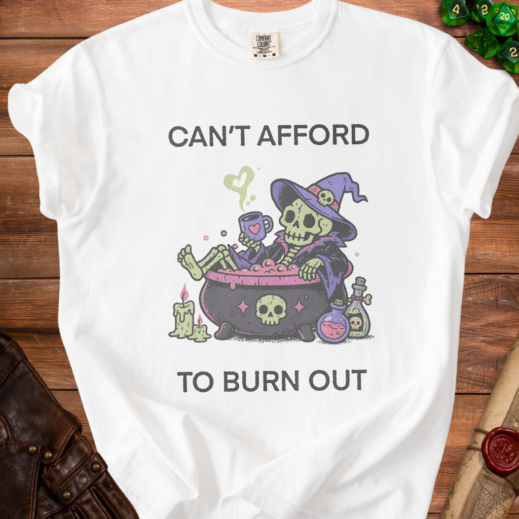 White t-shirt with skeleton in cauldron and "Can't Afford To Burn Out" text.