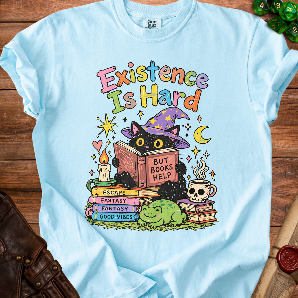 Light blue t-shirt with black cat reading "But Books Help" on stack of books.
