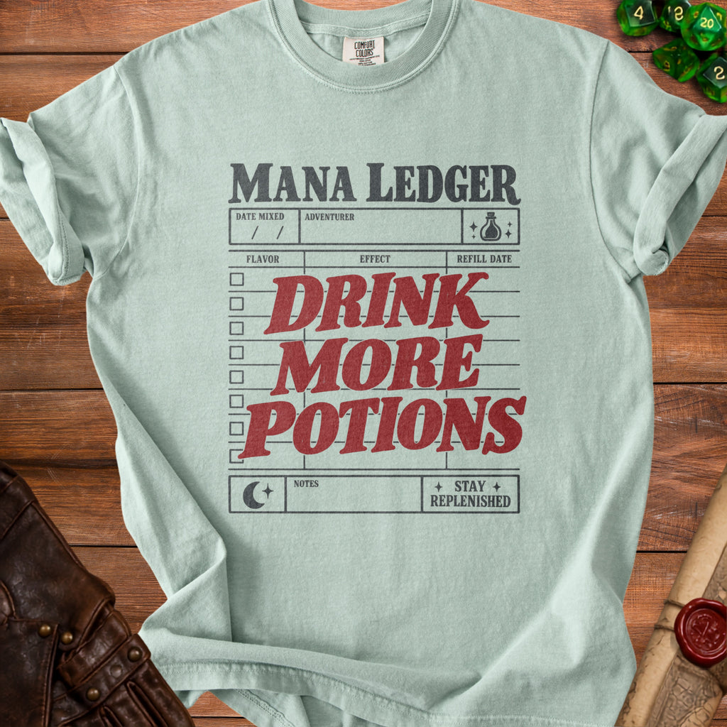 Light green t-shirt with "Mana Ledger" and "Drink More Potions" text design.