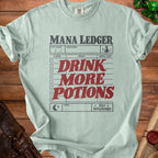 Light green t-shirt with "Mana Ledger" and "Drink More Potions" text design.