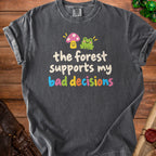 Dark gray t-shirt with text "the forest supports my bad decisions" and cute mushroom and frog graphics.