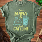Green t-shirt with "low MANA & high CAFFEINE" text and graphics.