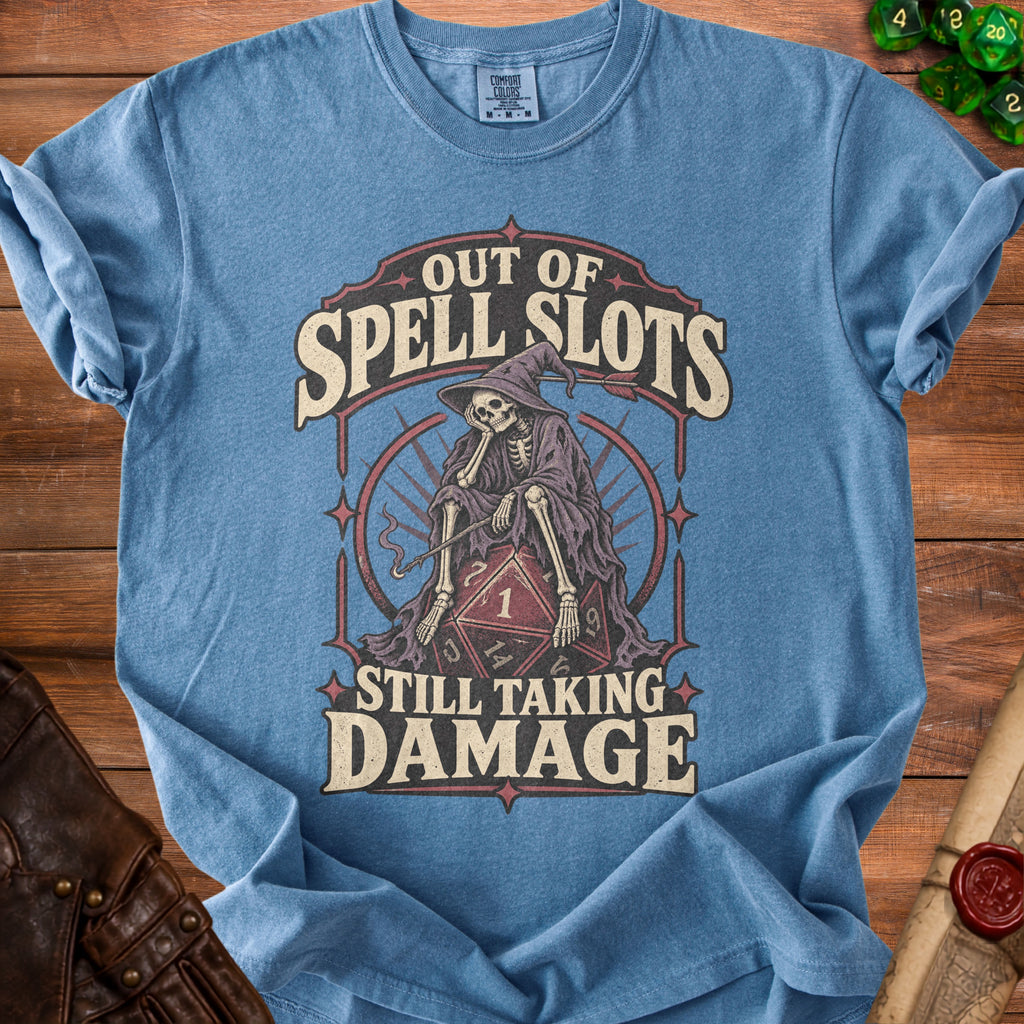 Blue t-shirt with skeleton graphic and text "Out of Spell Slots Still Taking Damage".