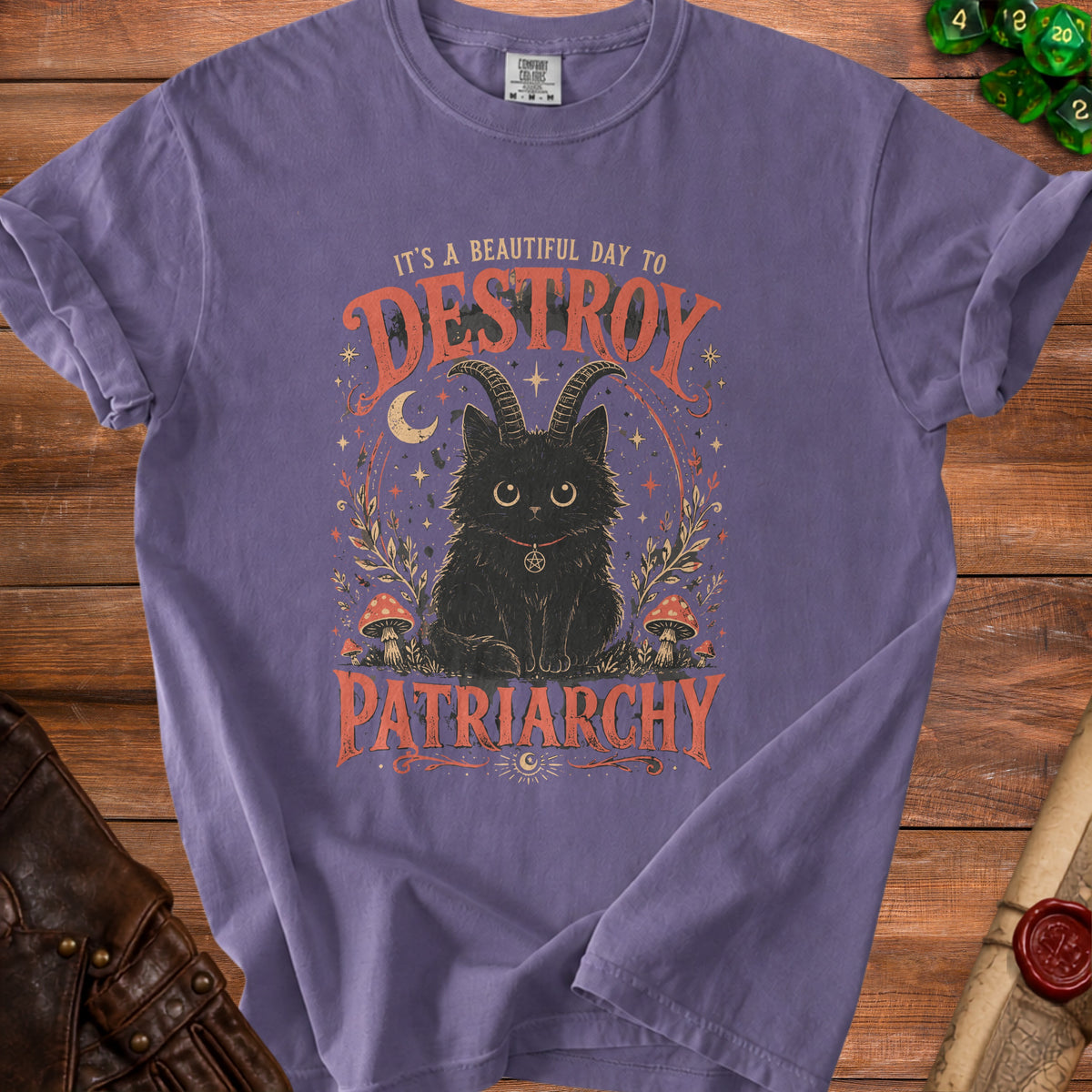 Purple t-shirt with graphic of a black cat with horns and text "It's a beautiful day to destroy patriarchy."