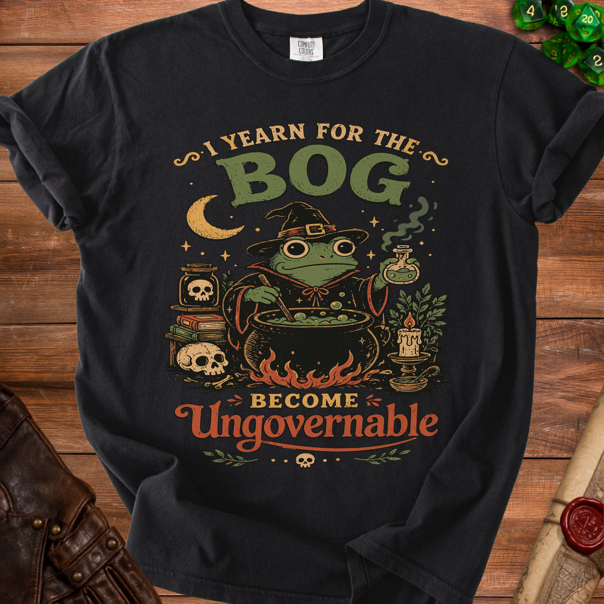 Black t-shirt with graphic of witch frog, cauldron, and text "I YEARN FOR THE BOG BECOME Ungovernable".