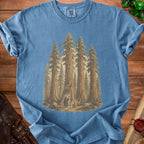 Blue t-shirt with forest scene featuring sequoia trees and small figures.