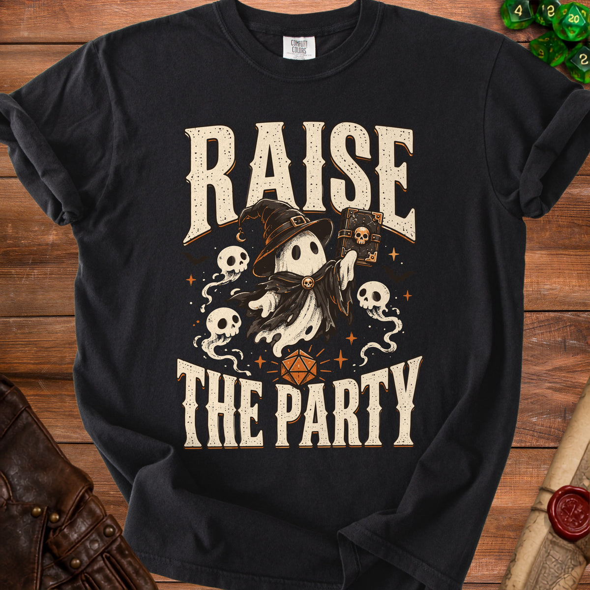 Black t-shirt with ghost wearing witch hat, holding spellbook, text "RAISE THE PARTY".