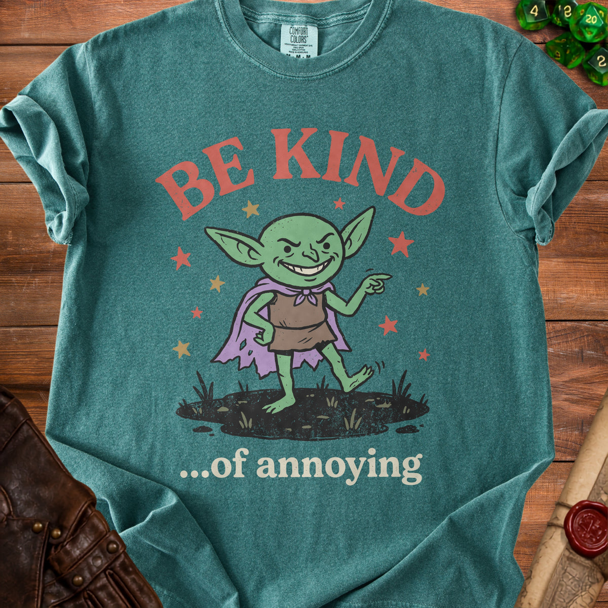 Green t-shirt with a mischievous goblin graphic and text "BE KIND...of annoying".