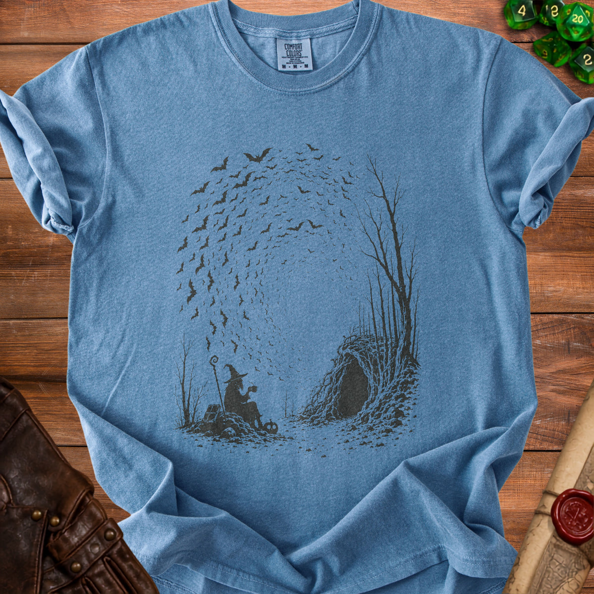 Blue t-shirt with a wizard, cave, and bats graphic, size medium.