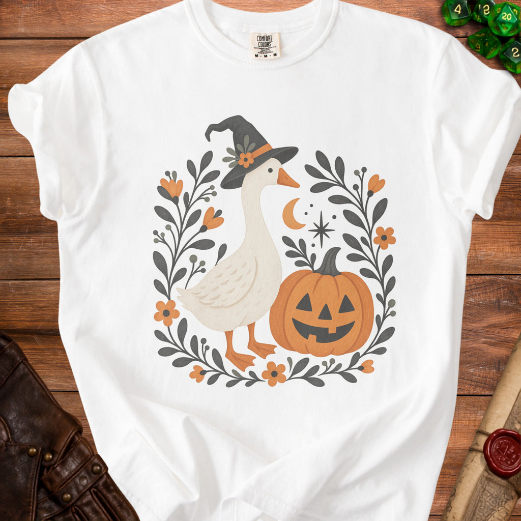White t-shirt with a graphic of a goose wearing a witch hat and a jack-o'-lantern.