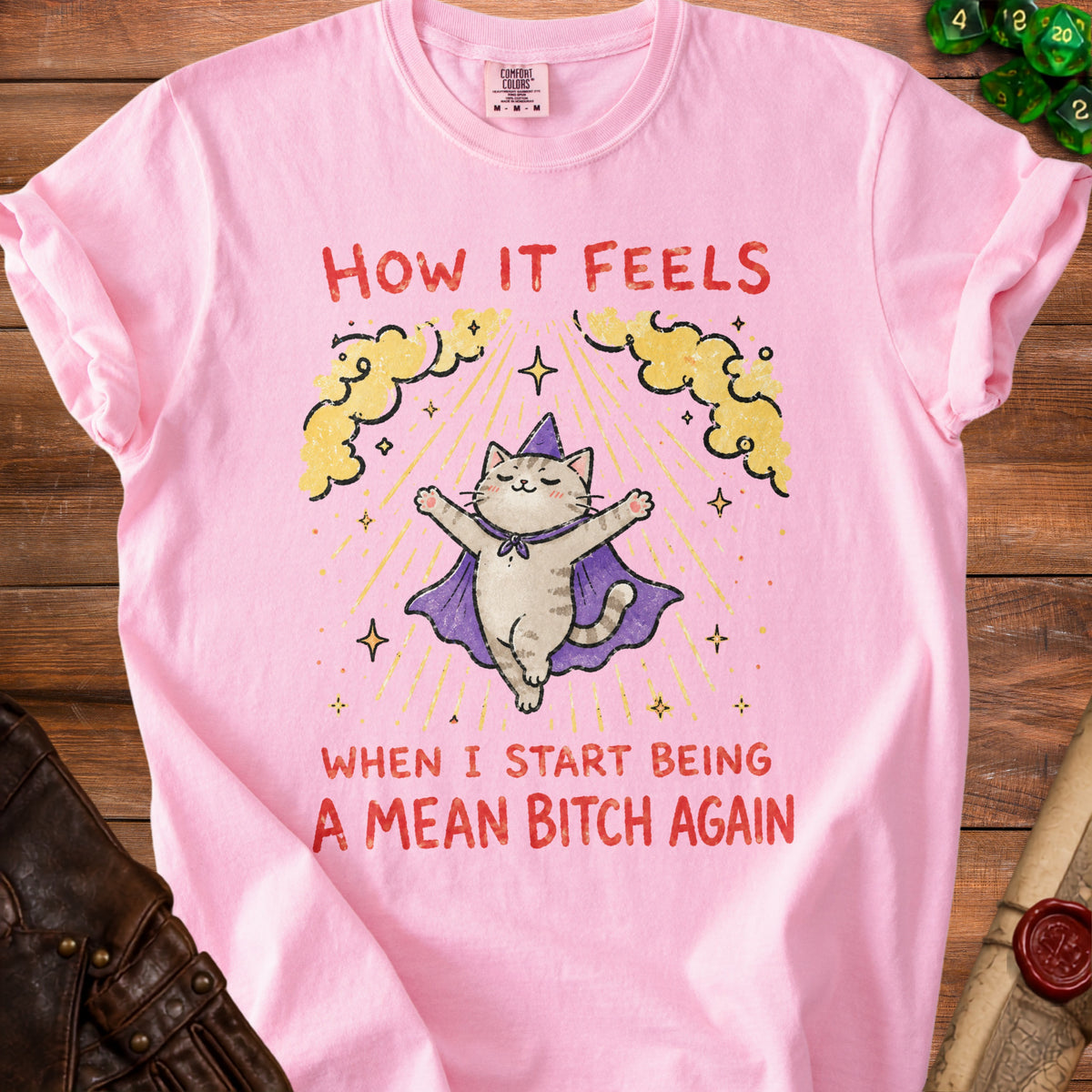 Pink t-shirt with a cat in a wizard hat and cape, text reads "How it feels when I start being a mean bitch again."