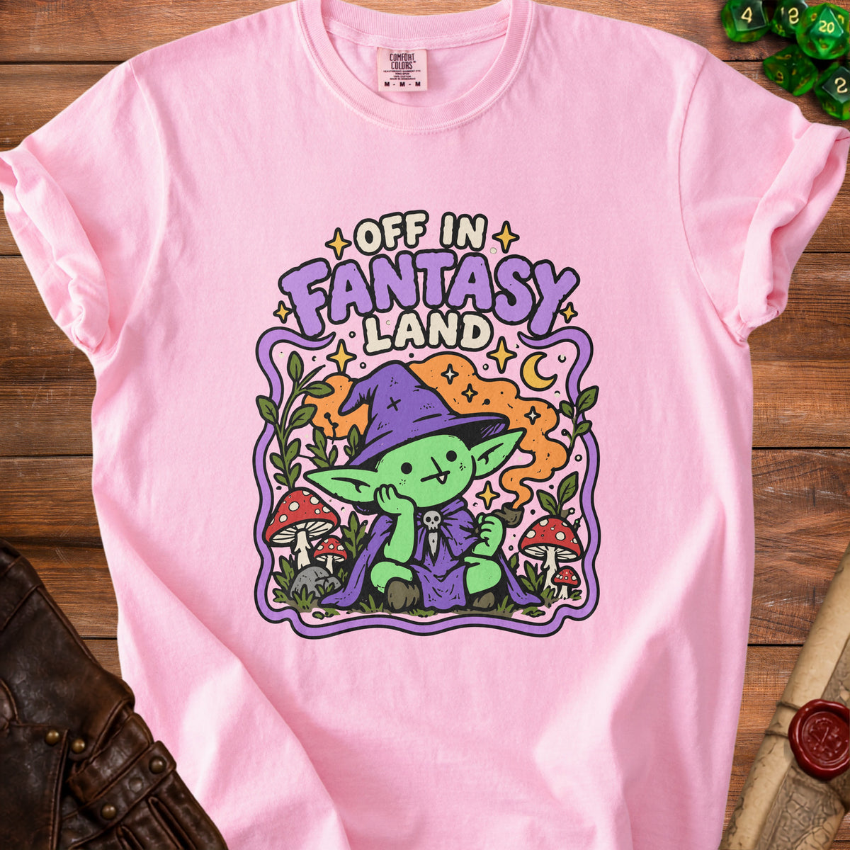 Pink t-shirt with a cute green goblin character reading "Off in Fantasy Land".