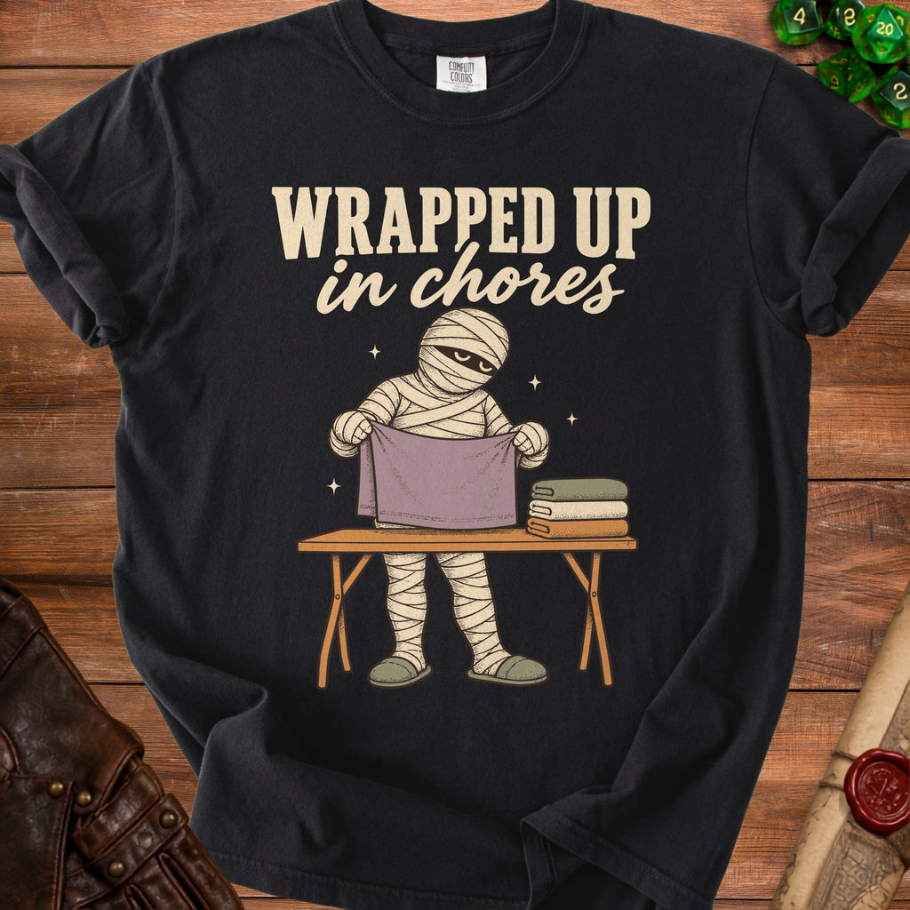 Mummy with "WRAPPED UP in chores" text folding clothes on a table.