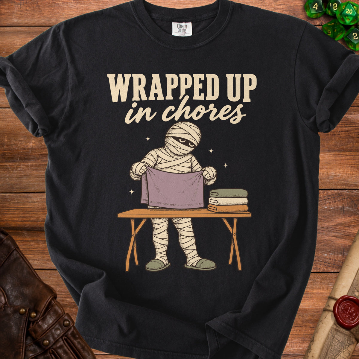 Mummy with "WRAPPED UP in chores" text folding clothes on a table.