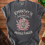 Dark grey t-shirt with skeleton on skateboard reading "Empathy is more rebellious than a middle finger."
