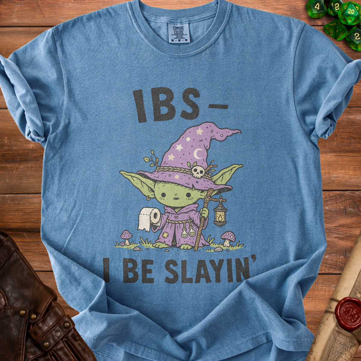 Blue t-shirt with a graphic of a wizardly creature and the text "IBS- I BE SLAYIN'".