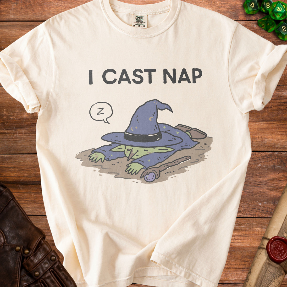 Cream t-shirt with text "I CAST NAP" and illustration of a sleeping wizard.