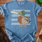Blue t-shirt with a duck holding a sword in front of striped background.