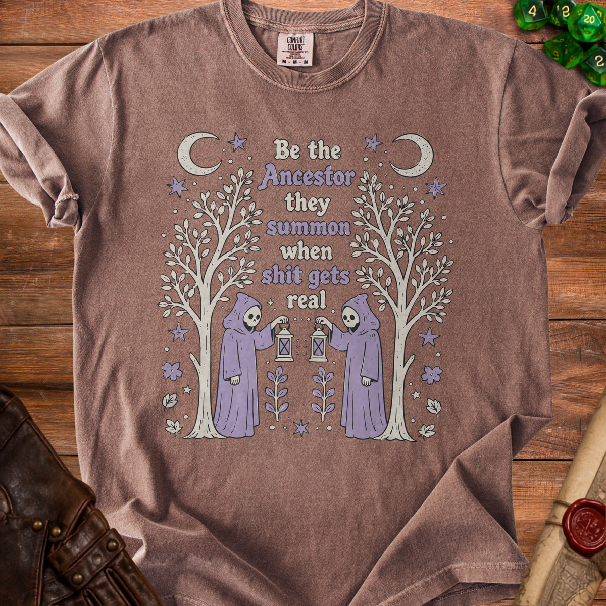 Brown t-shirt with "Be the Ancestor they summon when shit gets real" graphic.