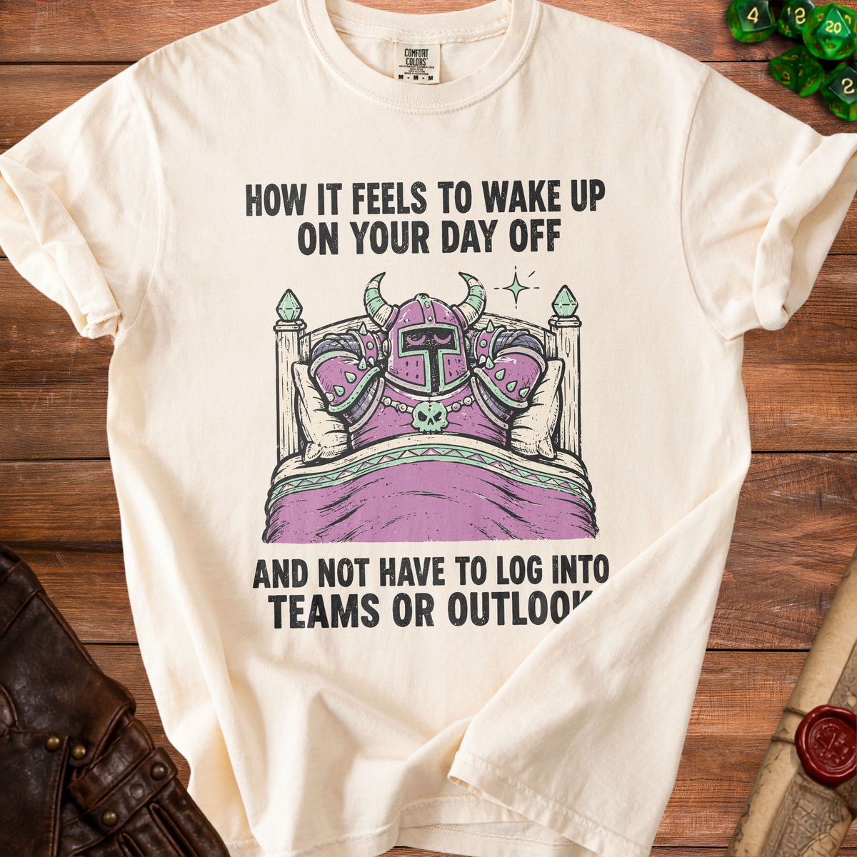 Cream t-shirt with a knight in armor sleeping in a bed and text.
