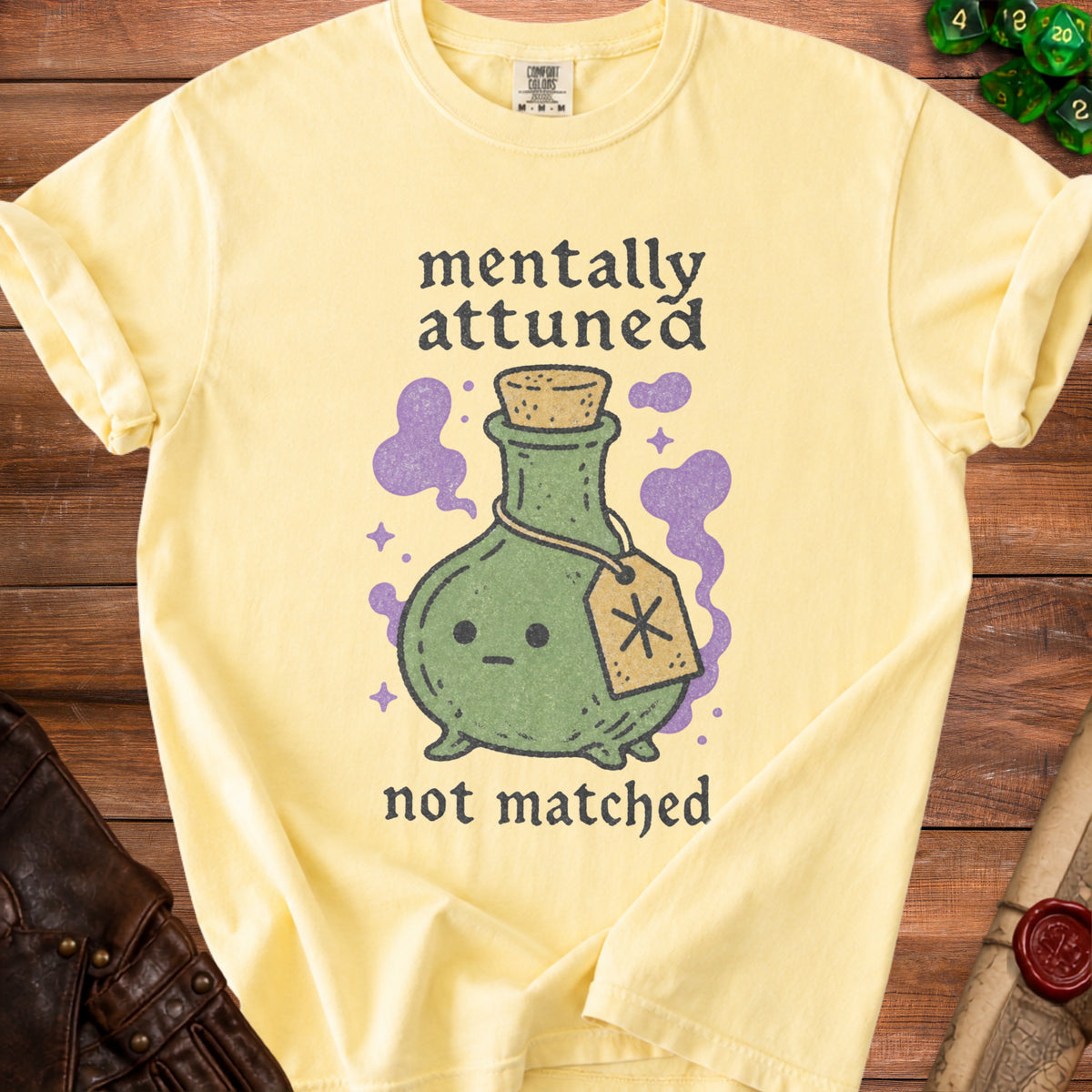 Yellow t-shirt with text "mentally attuned not matched" and a potion bottle graphic.