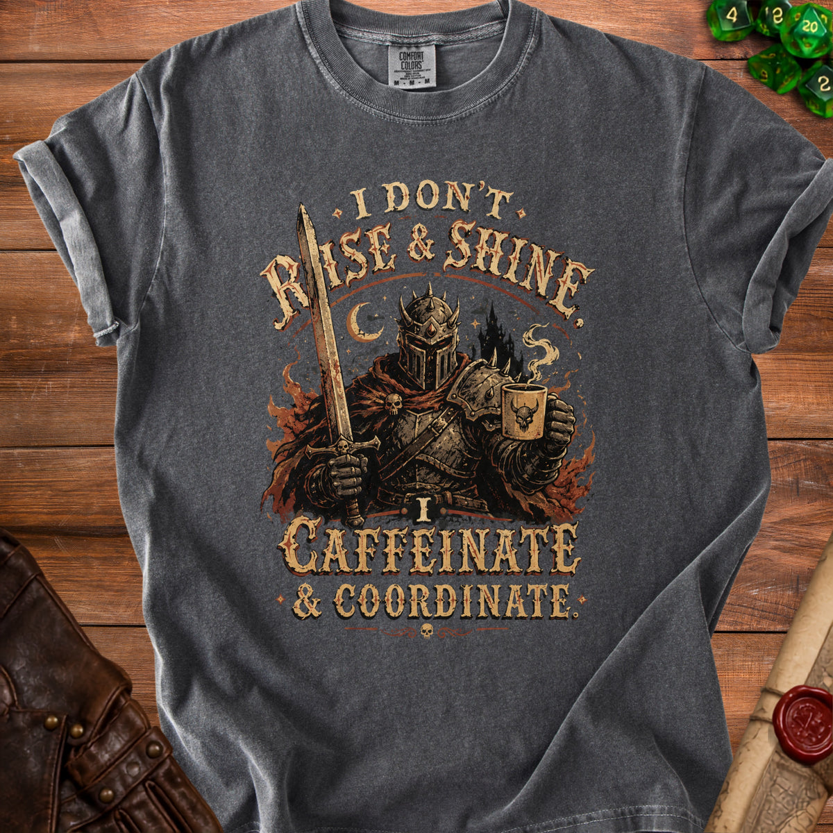 Dark gray t-shirt with knight holding sword and coffee mug, text reads "I DON'T RISE & SHINE. I CAFFEINATE & COORDINATE."