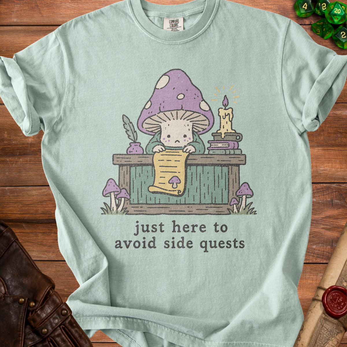 Light teal t-shirt with a cute mushroom character reading a scroll and the text "just here to avoid side quests".