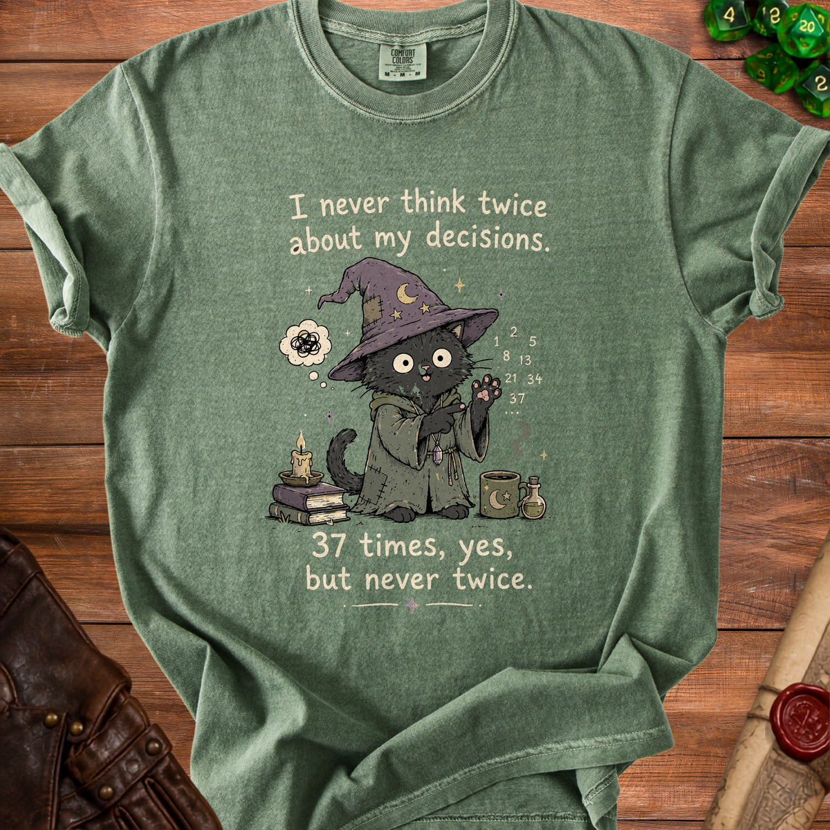 Green t-shirt with a black cat wizard, books, candle, mug, and text.