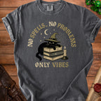 Gray t-shirt with a black cat wearing a witch hat, on books, with text "NO SPELLS, NO PROBLEMS ONLY VIBES".