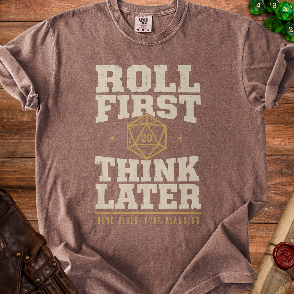 Brown t-shirt with "Roll First Think Later" and a D20 dice.