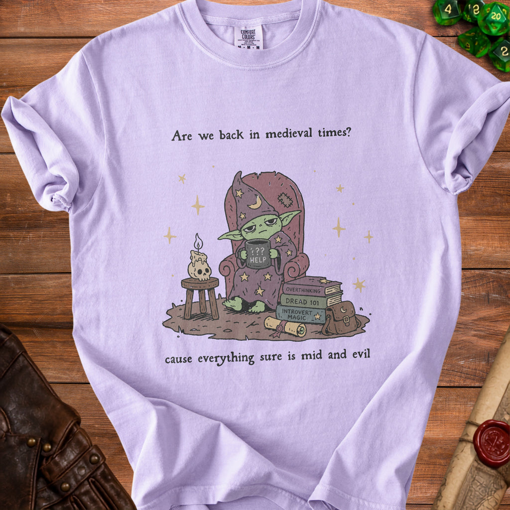Lavender t-shirt with a green creature in a wizard hat holding "HELP" and surrounded by books.