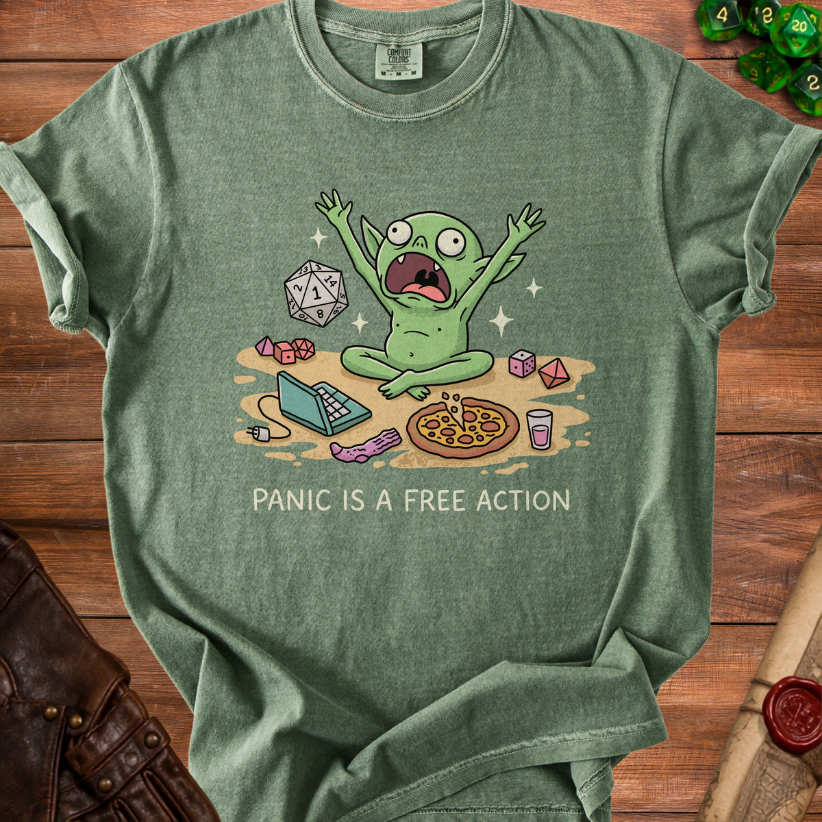 Green t-shirt with a cartoon goblin, dice, laptop, pizza, and text "PANIC IS A FREE ACTION".