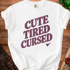 White t-shirt with burgundy text "CUTE TIRED CURSED" and heart graphic.