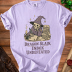 Skeleton in wizard hat writing at desk with stack of letters; text "Dragon Slain, Inbox Undefeated".