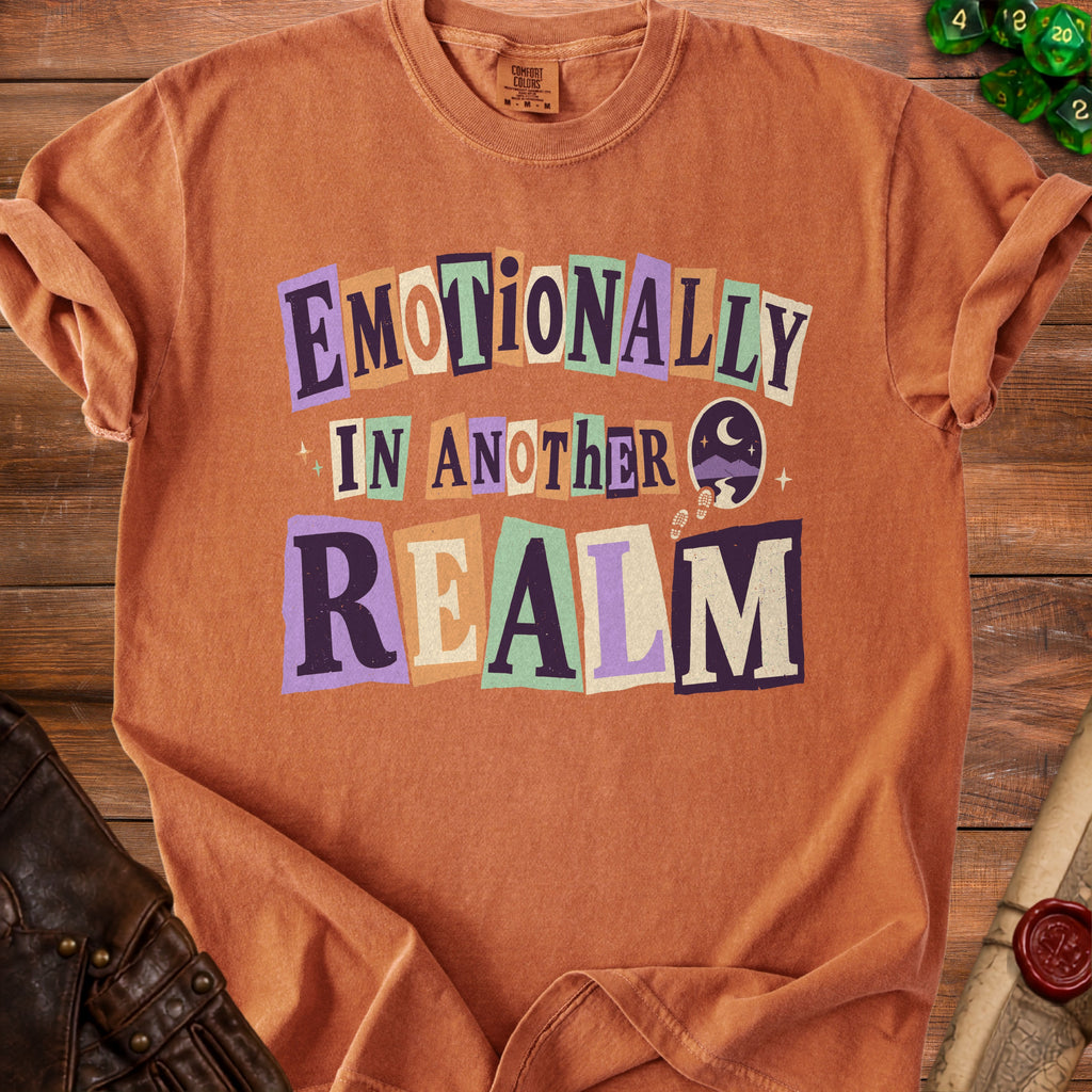 Orange t-shirt with "Emotionally In Another Realm" text and celestial graphic.