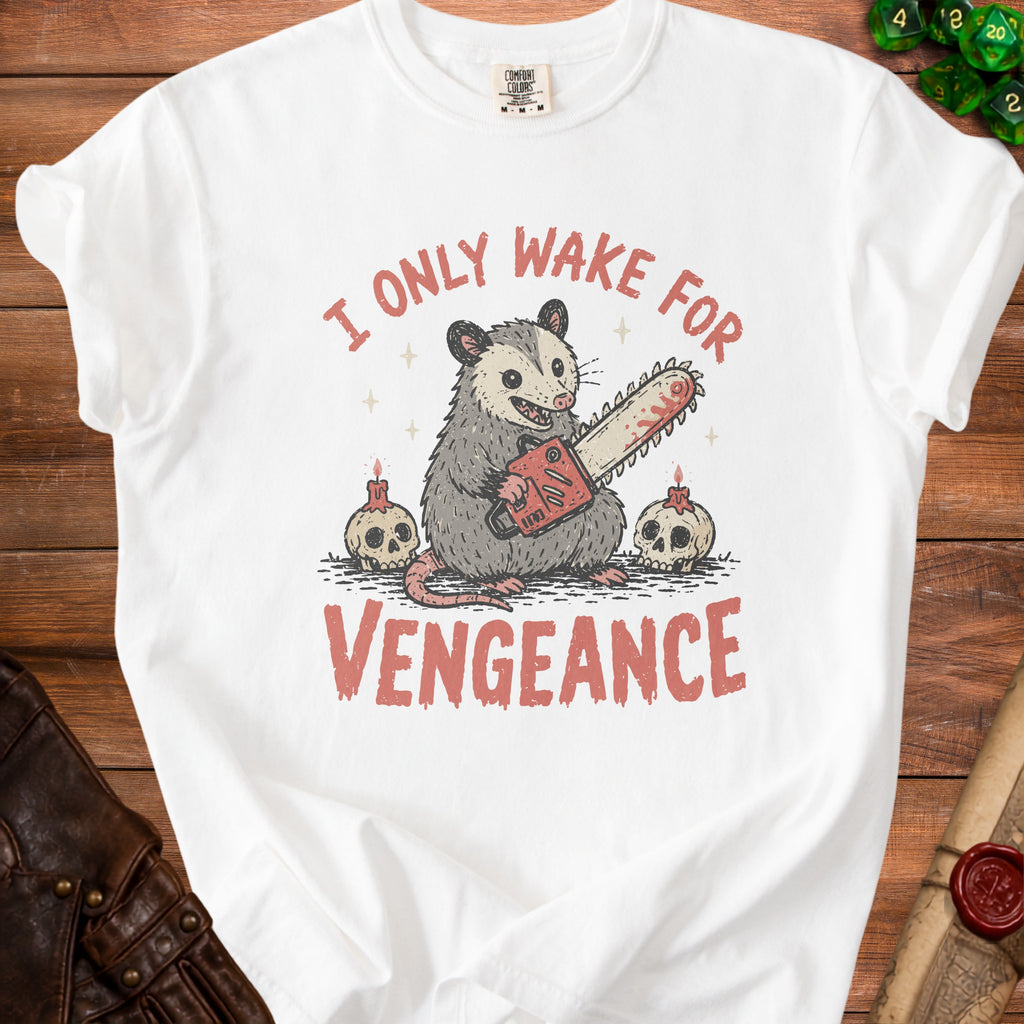 White t-shirt with an opossum holding a chainsaw, flanked by skulls and candles, text reads "I ONLY WAKE FOR VENGEANCE".