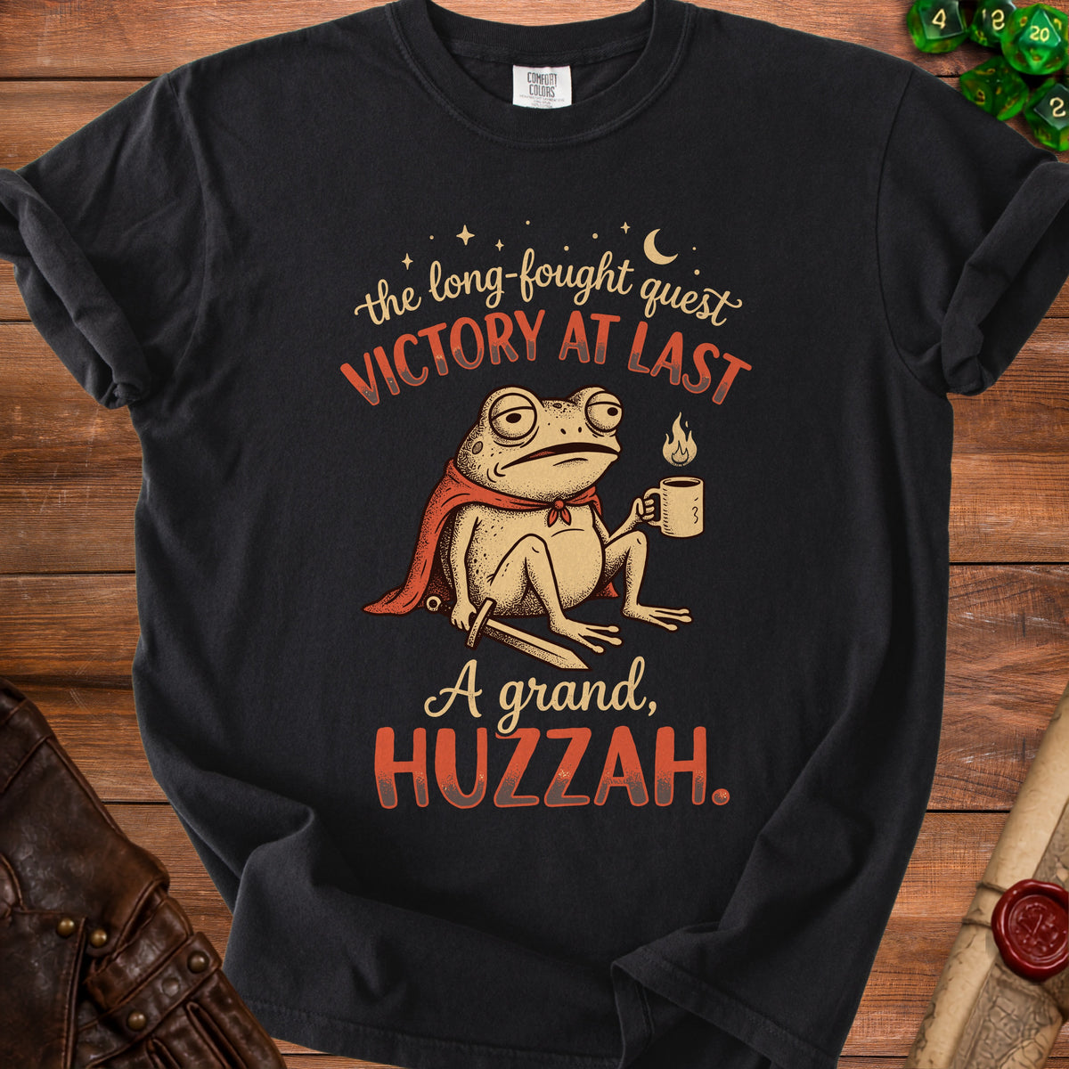 T-shirt with a frog wearing a cape, holding a mug, and text "VICTORY AT LAST" and "A grand, HUZZAH."