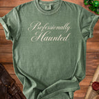 Green t-shirt with "Professionally Haunted" text in script font.