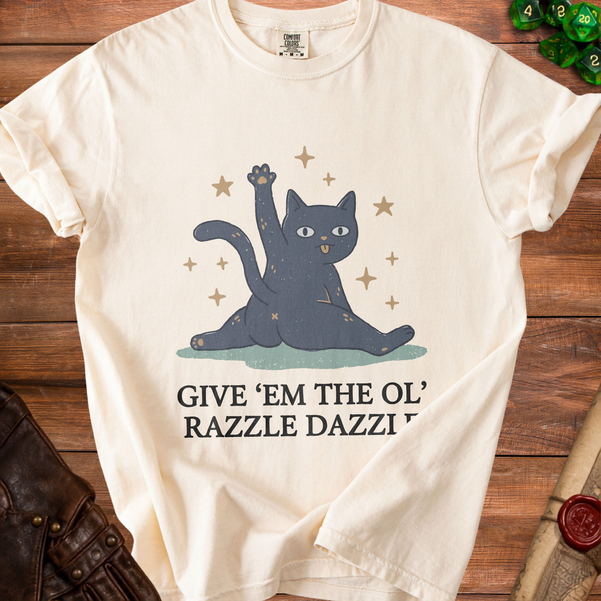 Cream t-shirt with a graphic of a black cat and the text "GIVE 'EM THE OL' RAZZLE DAZZI".
